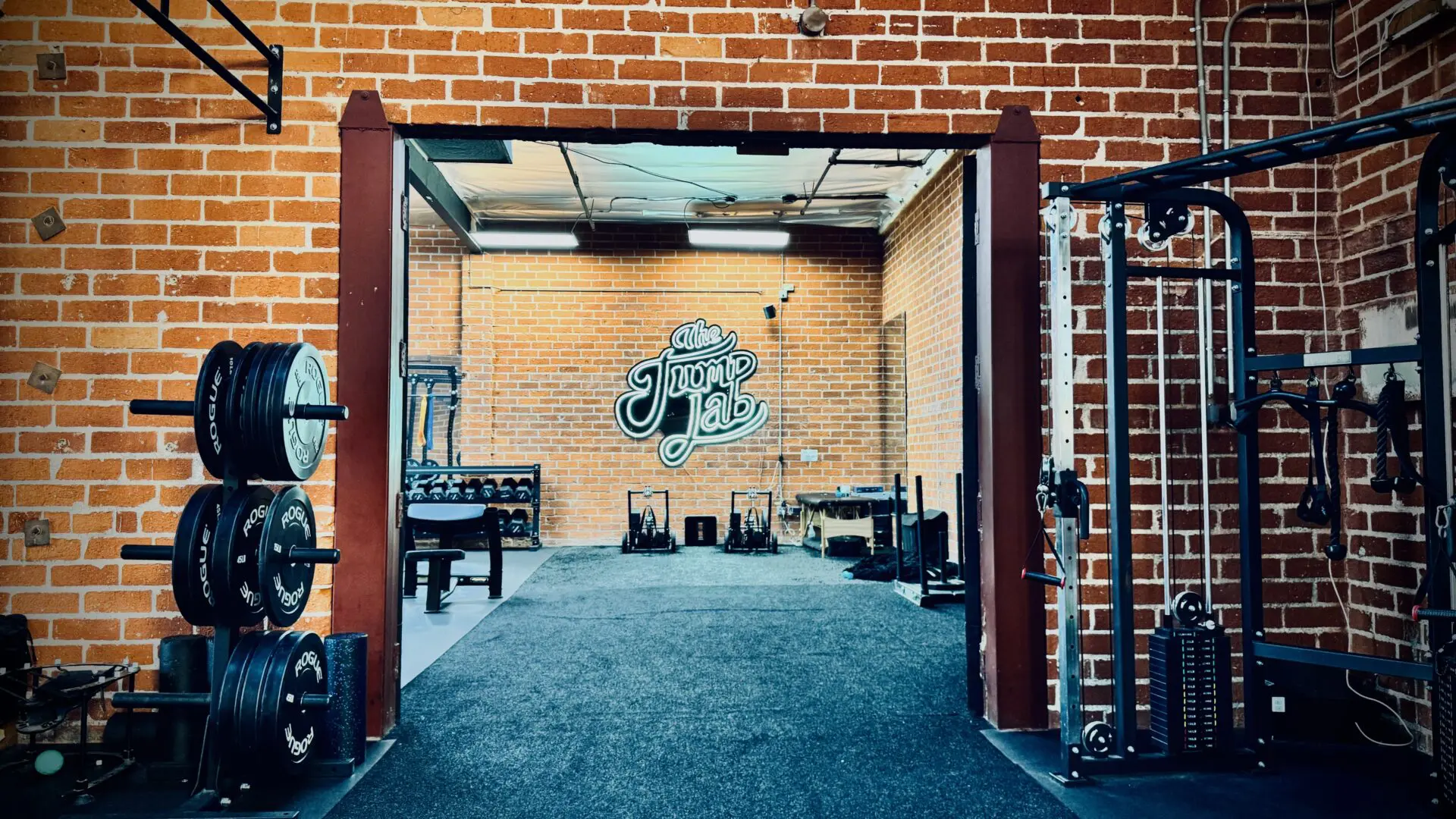 A gym with a brick wall and a bench