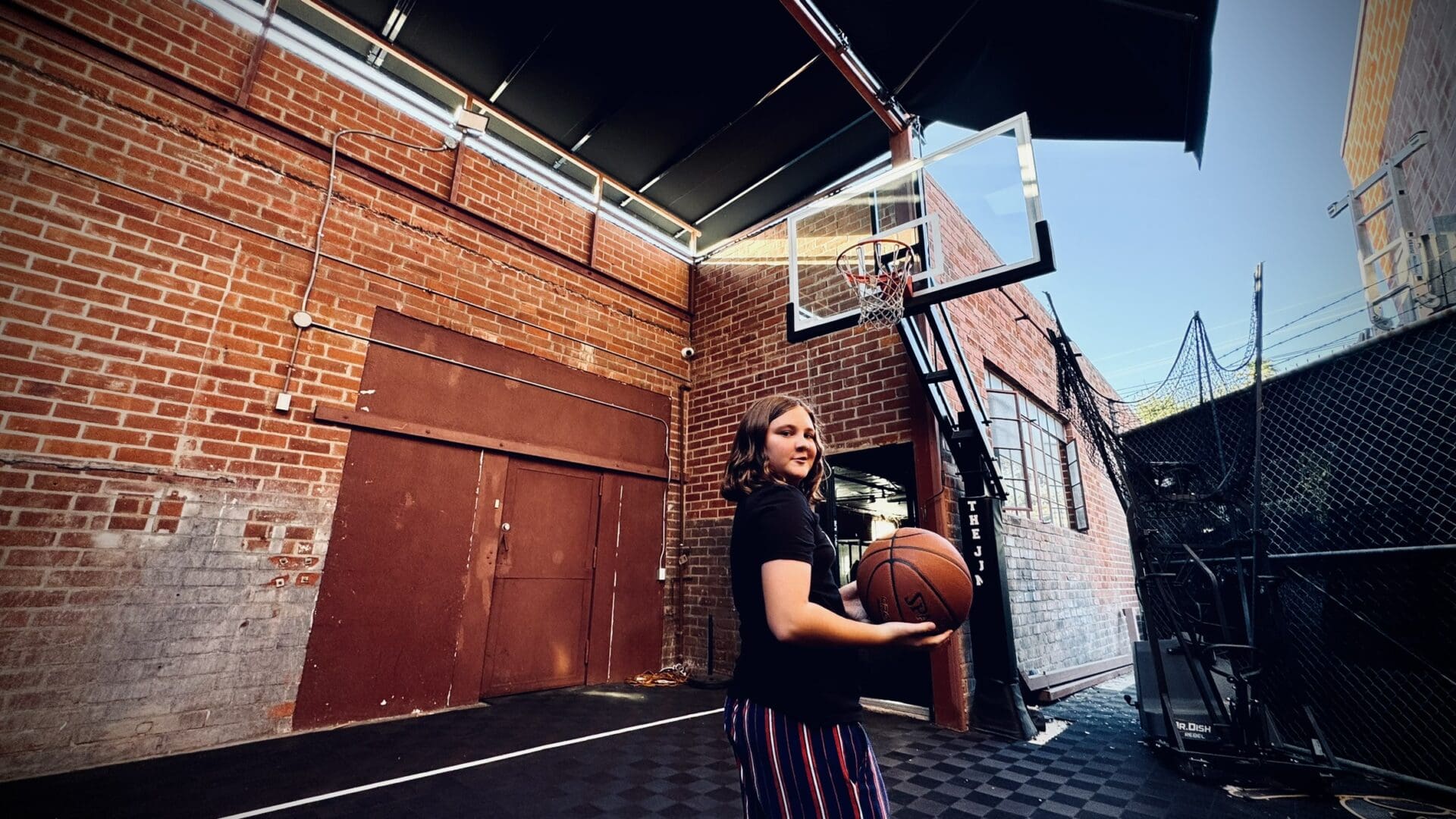 A woman holding onto a basketball in her hand