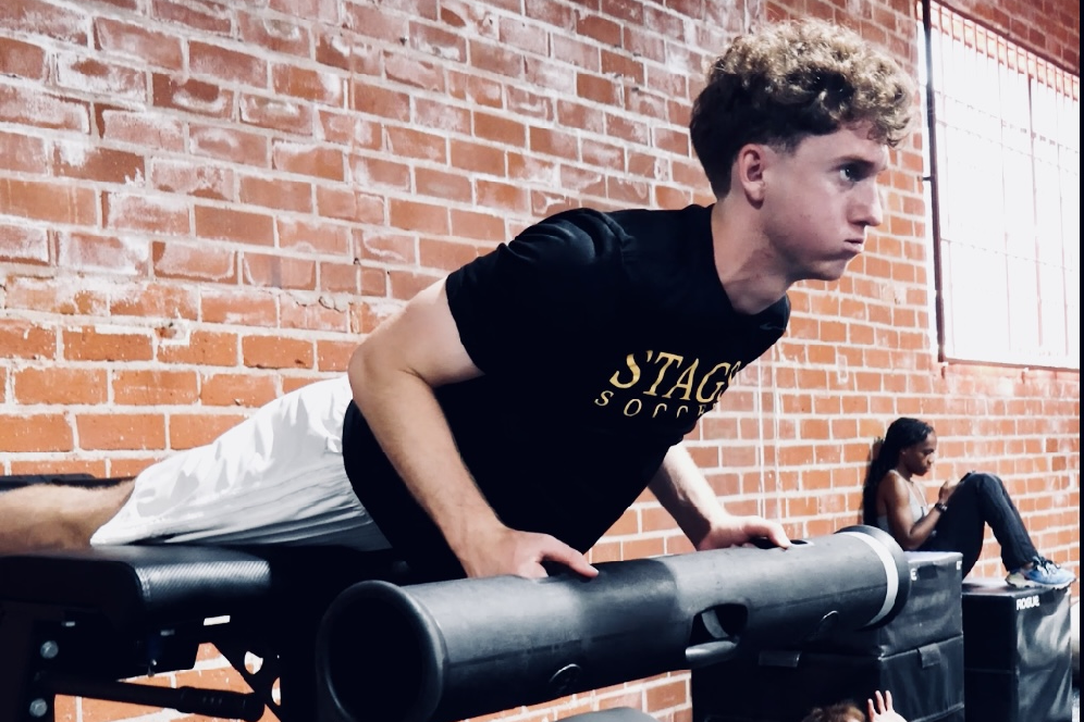 A young man is doing push ups on the bench.