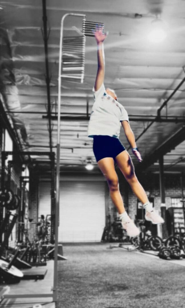 Athlete mid-air vertical jump in gym