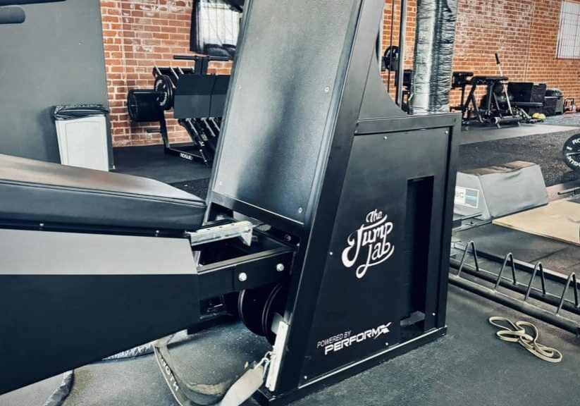 A black machine in a gym with brick walls.